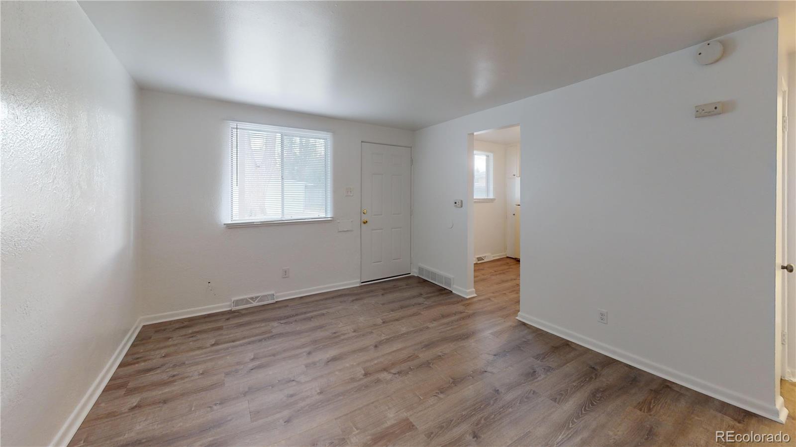 1251 Upham Street, Unit 8 Lakewood, CO 80214 - Photo 35 of 38 an empty room with wooden floor and windows
