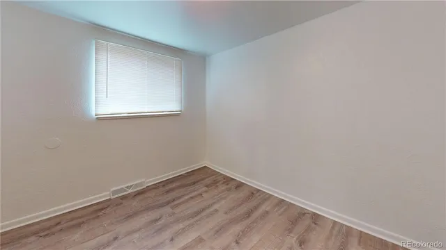 a view of a small space with wooden floor and a window
