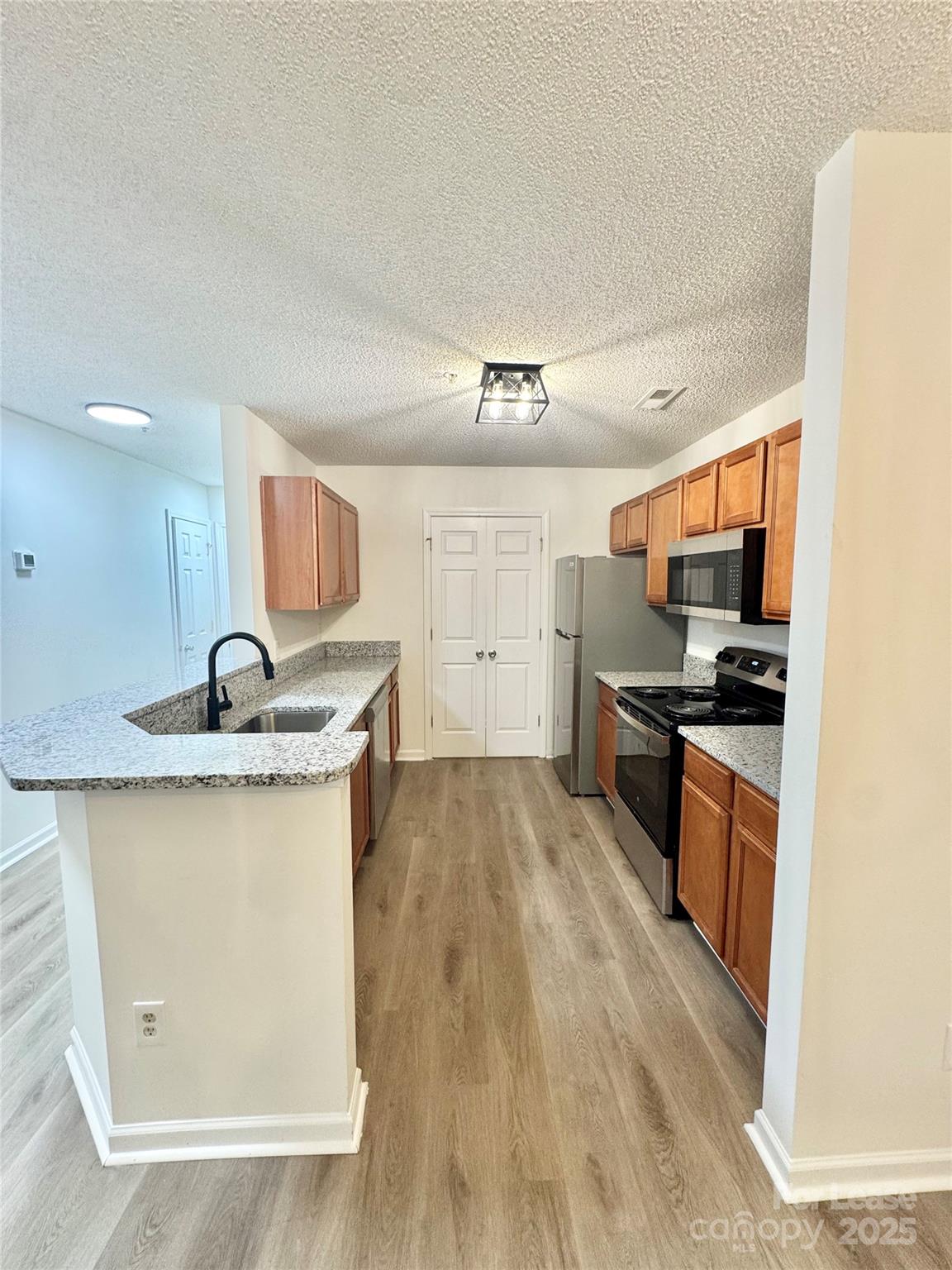 315 Flint Hill Road, Unit 202 Fort Mill, SC 29715 - Photo 2 of 14 a kitchen with granite countertop a sink and stainless steel appliances
