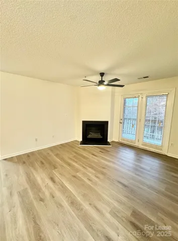 a view of empty room with wooden floor and fireplace