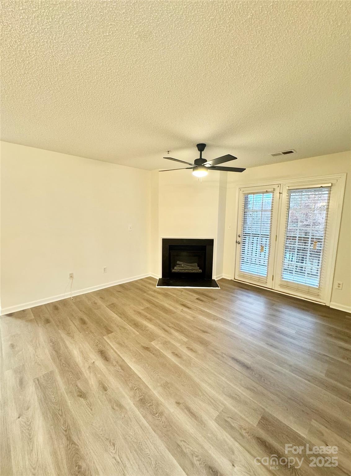 315 Flint Hill Road, Unit 202 Fort Mill, SC 29715 - Photo 6 of 14 a view of empty room with wooden floor and fireplace