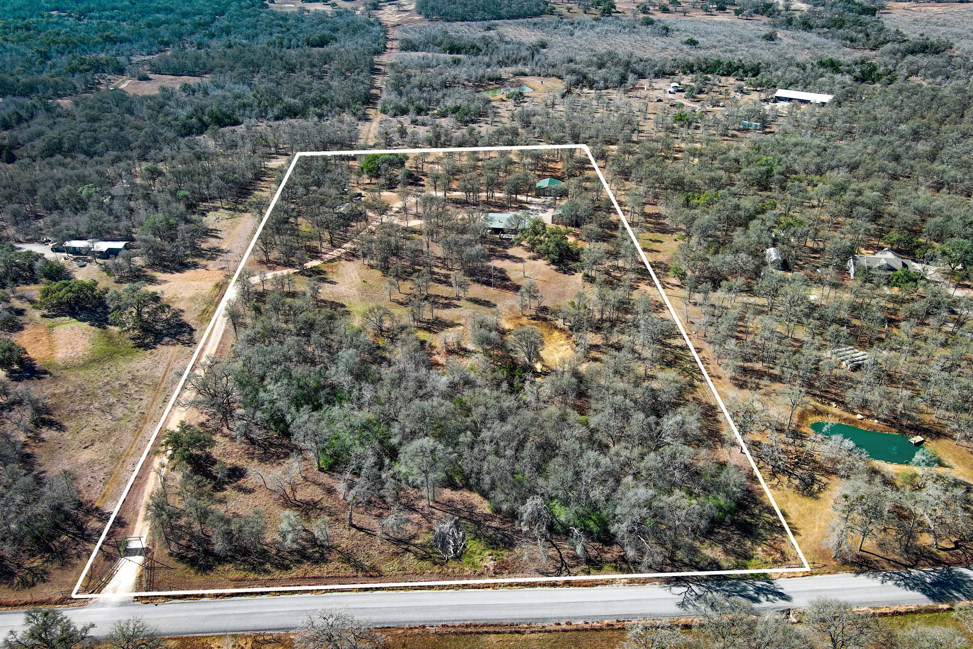 1675 Watterson Road Red Rock, TX 78662 - Photo 4 of 35 Aerial view of property with approximate property boundaries highlighted and a heavily wooded area
