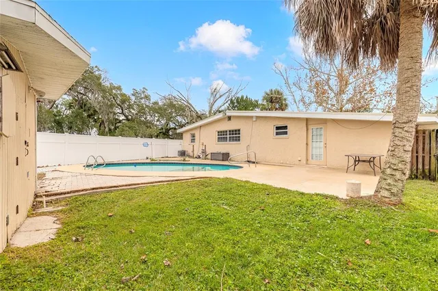 a view of a white house with a swimming pool and sitting area