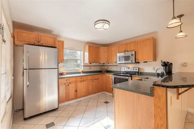 a kitchen with stainless steel appliances granite countertop a refrigerator sink stove microwave and cabinets