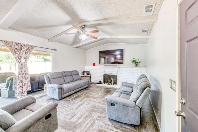 a living room with furniture a fireplace and a flat screen tv