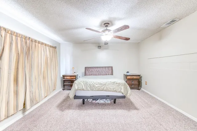 a spacious bedroom with a bed and a chandelier
