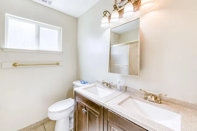 a bathroom with a sink vanity mirror and toilet