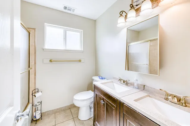 a bathroom with a granite countertop sink toilet and mirror