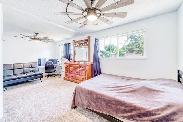 a bedroom with a bed a chandelier and a window