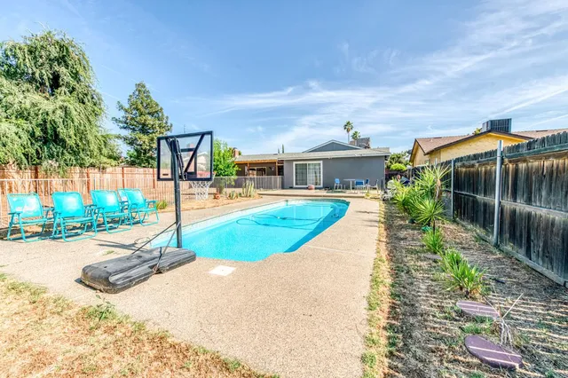 a view of a white house with a yard garden and plants