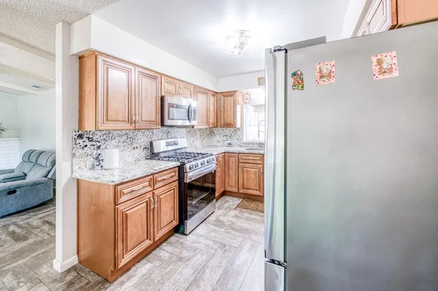 a kitchen with stainless steel appliances granite countertop a sink stove and refrigerator