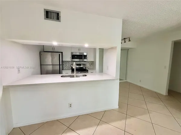 a kitchen with stainless steel appliances a refrigerator sink and microwave
