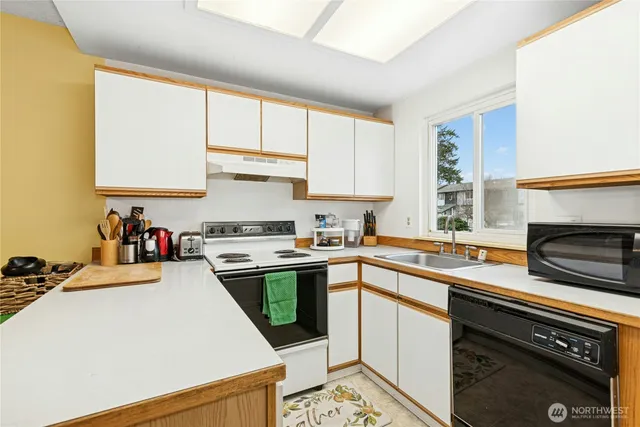a kitchen with a sink a stove and cabinets