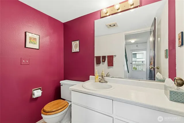 a bathroom with a sink vanity mirror and toilet