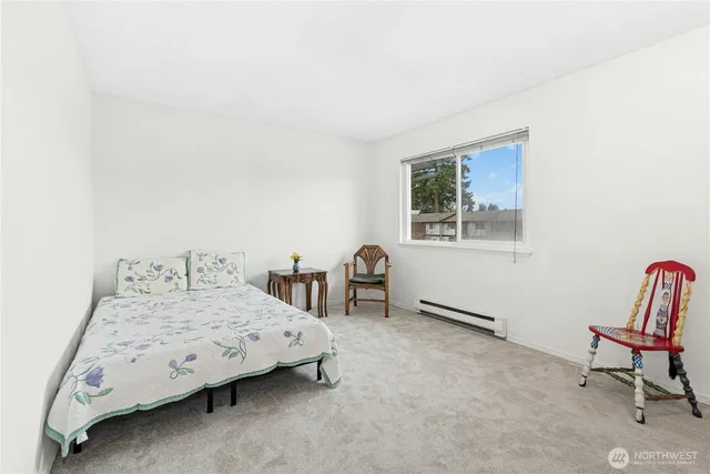 a bedroom with a bed chair and window