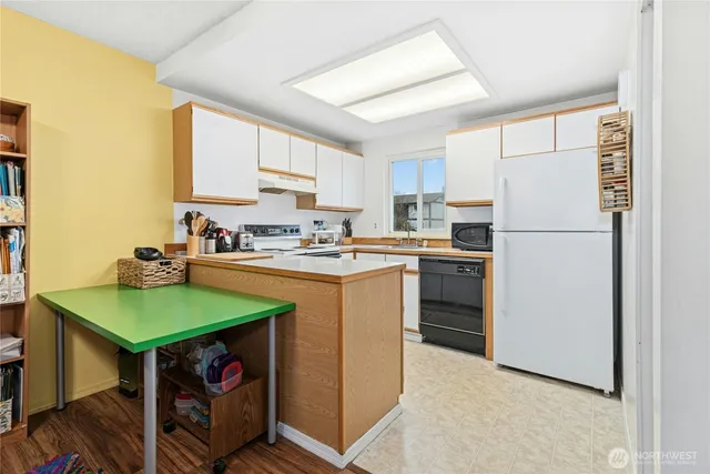 a kitchen with a refrigerator a stove a sink and a cabinets