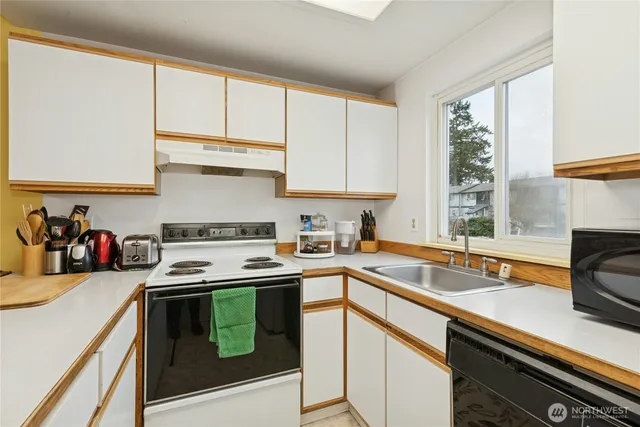a kitchen with a stove a sink and cabinets