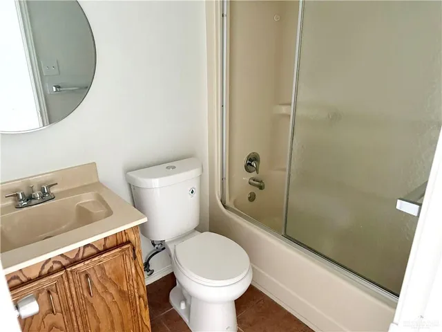 a white toilet sitting next to a bathroom sink and vanity