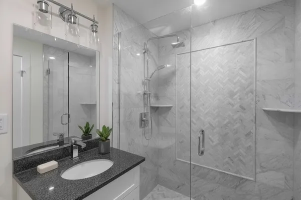 a bathroom with a sink shower and a mirror