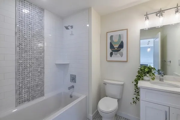 a bath room with a toilet a sink and a bath tub
