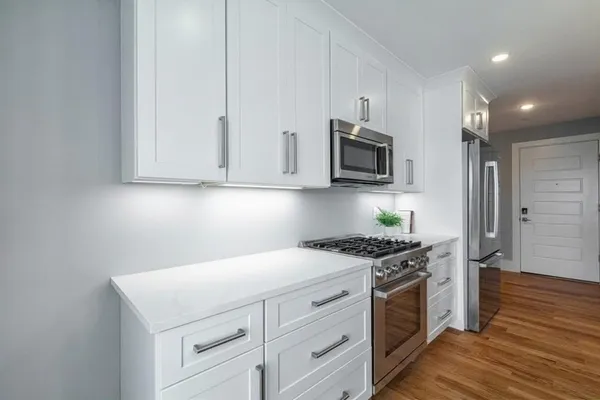 a kitchen with stainless steel appliances granite countertop a stove a refrigerator and a microwave