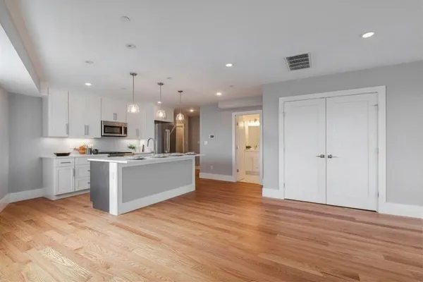 a large kitchen with a lot of counter space and stainless steel appliances