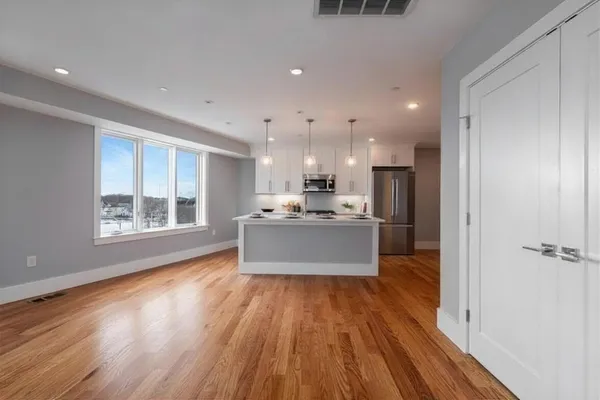 a large kitchen with kitchen island a island wooden floors and stainless steel appliances