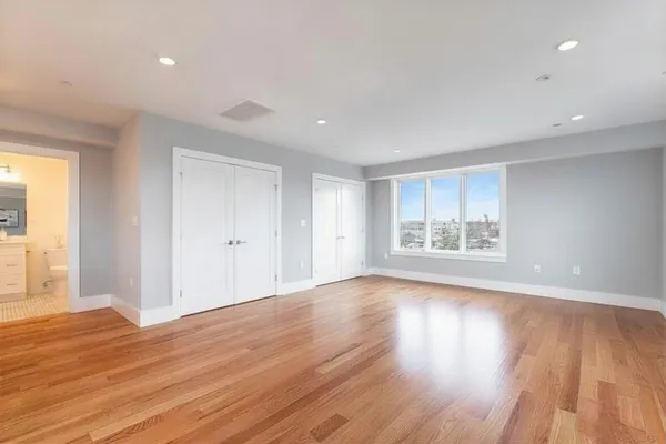a view of a room with wooden floor and window