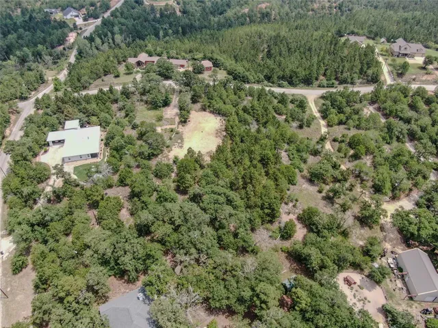 an aerial view of residential house with outdoor space and trees all around