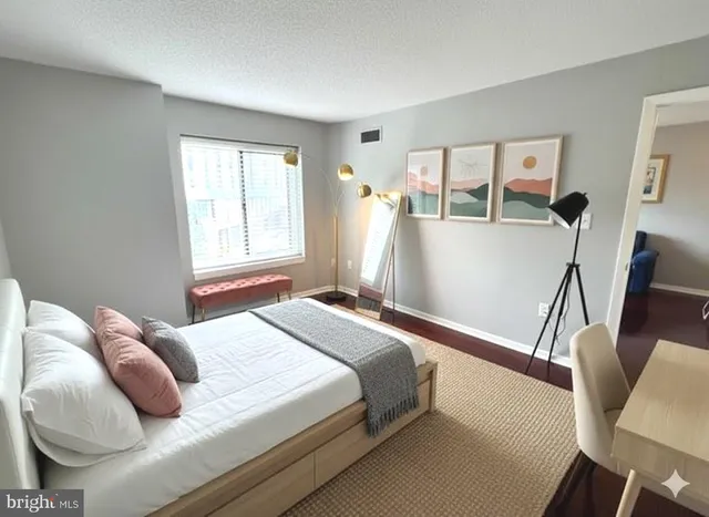 a bedroom with a bed and wooden floor