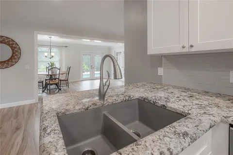 a kitchen with cabinets stainless steel appliances and wooden floor