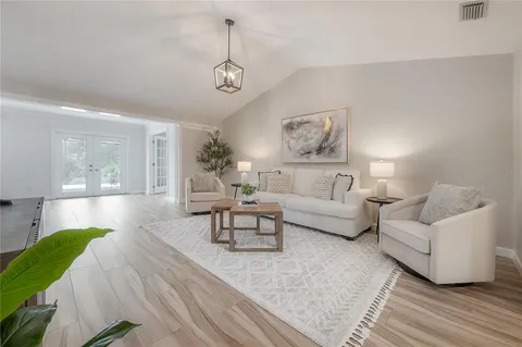 a living room with furniture and a wooden floor