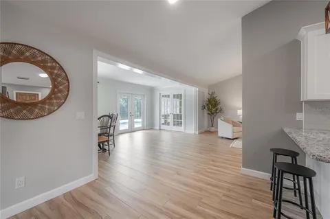 a kitchen with stainless steel appliances granite countertop a refrigerator a stove a sink dishwasher and white cabinets with wooden floor