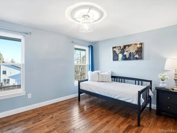 a bedroom with a bed and wooden floor
