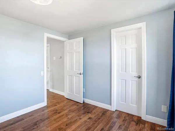a view of an empty room with wooden floor