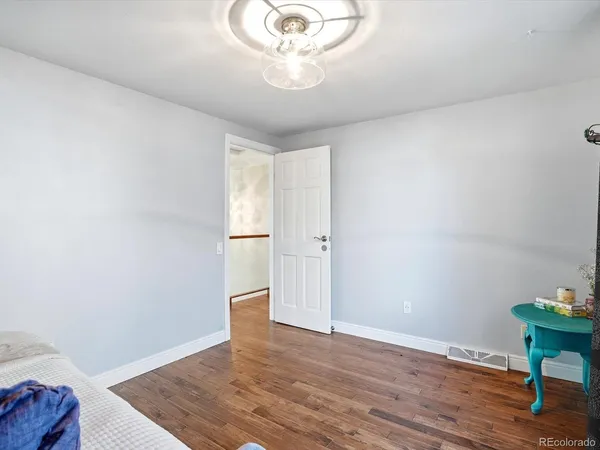 a view of an empty room with wooden floor