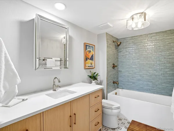 a bathroom with a granite countertop sink toilet and shower