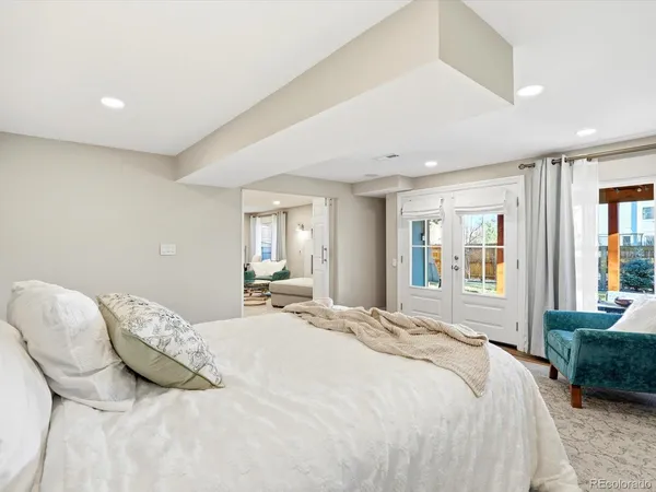 a bedroom with a large bed and wooden floor