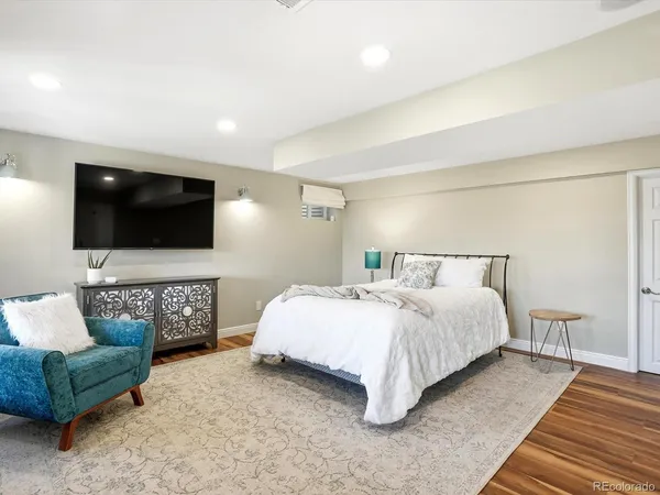 a spacious bedroom with a bed and a flat screen television