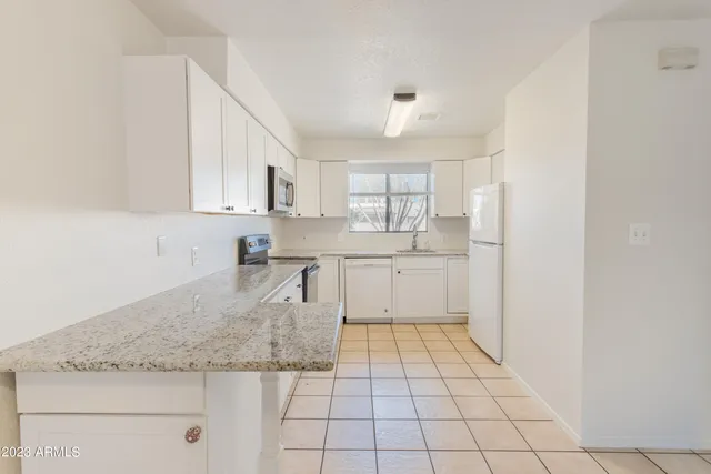 a kitchen with a sink window and cabinets