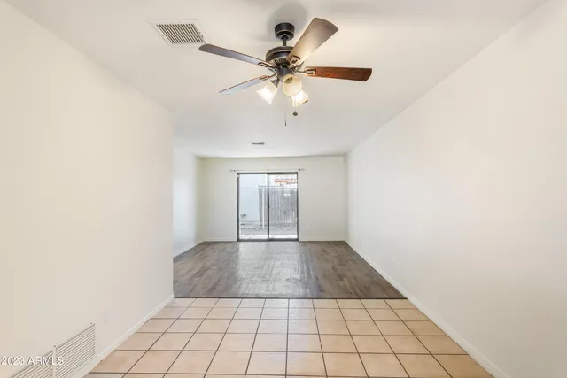 an empty room with fan and windows