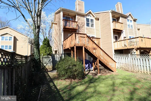 a view of a house with a small yard and wooden fence