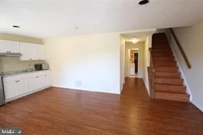 a view of a kitchen with wooden floor and electronic appliances