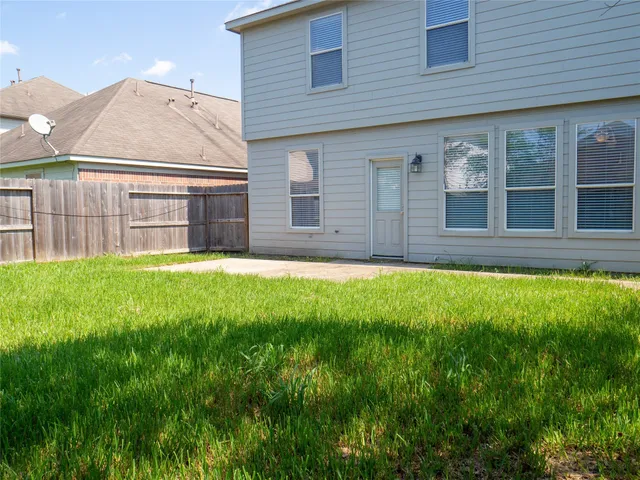 a view of house with backyard and a tub
