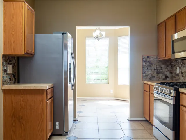 a kitchen with stainless steel appliances granite countertop a refrigerator and a stove