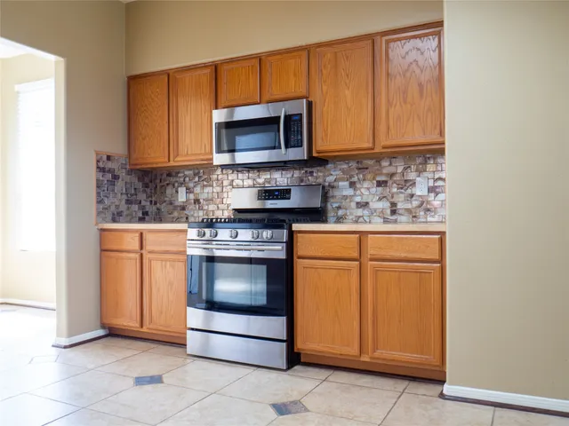 a kitchen with stainless steel appliances granite countertop a stove microwave and oven