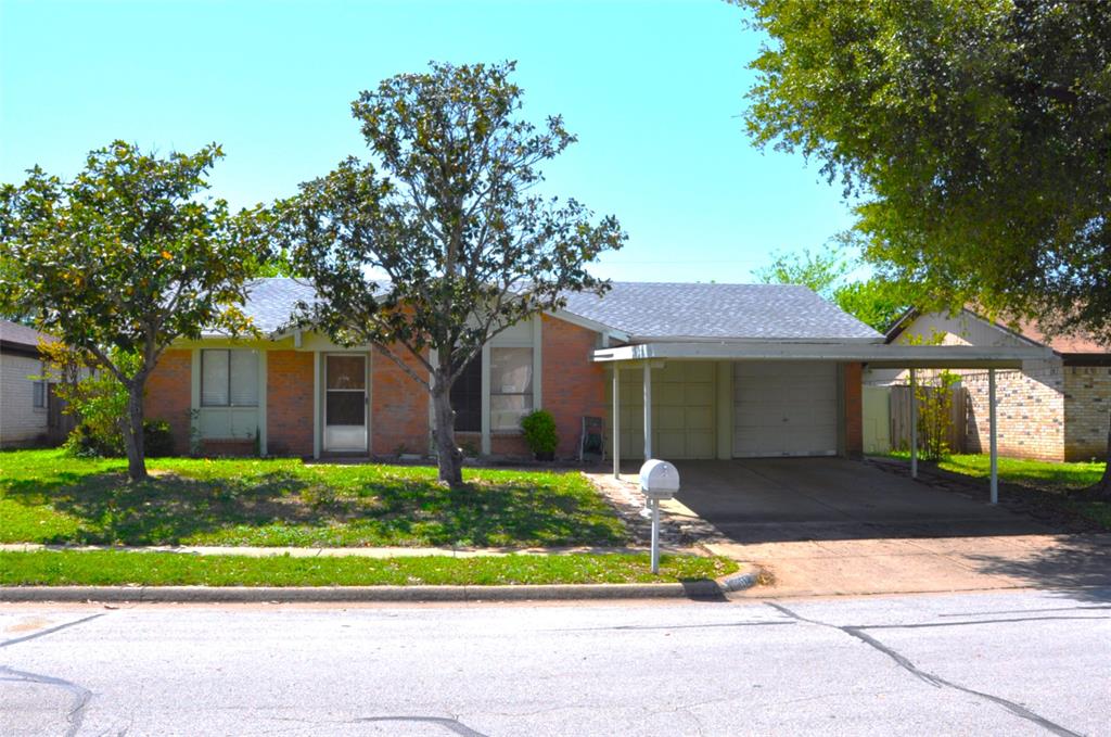 View of front of home with a carport, a garage, concrete driveway, and brick 