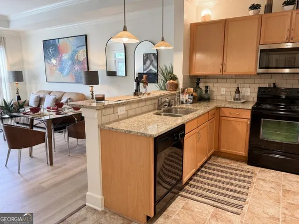 a kitchen with stainless steel appliances granite countertop a sink stove and cabinets