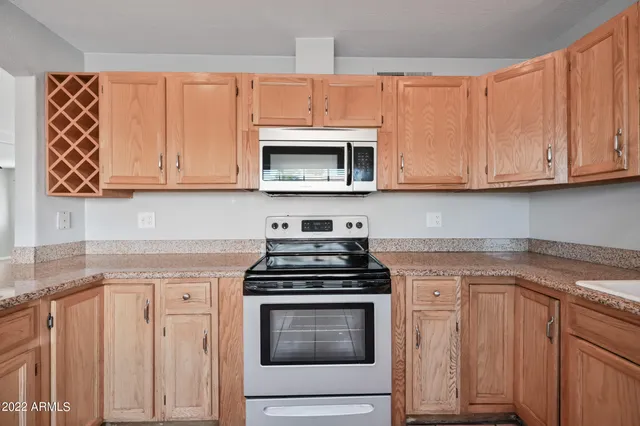 a kitchen with granite countertop cabinets stainless steel appliances and a sink