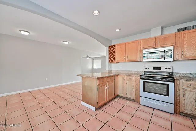 a kitchen with stainless steel appliances granite countertop a stove a sink and a microwave